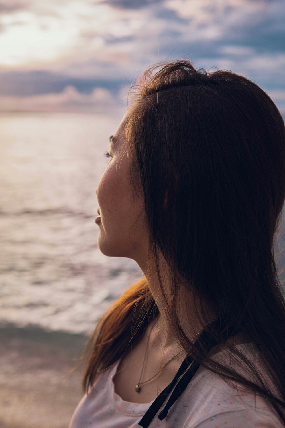 woman in white shirt standing on beach during daytime