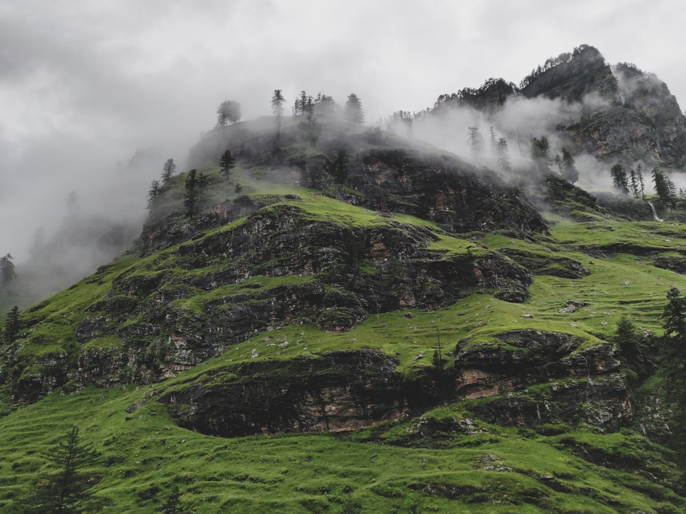 green grass covered mountain under cloudy sky during daytime