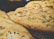Golden-brown flatbreads with a textured surface, topped with an even distribution of chopped herbs. The breads have a crispy and slightly uneven crust, indicating a freshly baked texture.