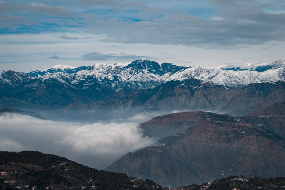 snow covered mountains under cloudy sky during daytime