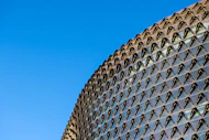 A large laminated glass facade on a commercial building under bright daylight.
