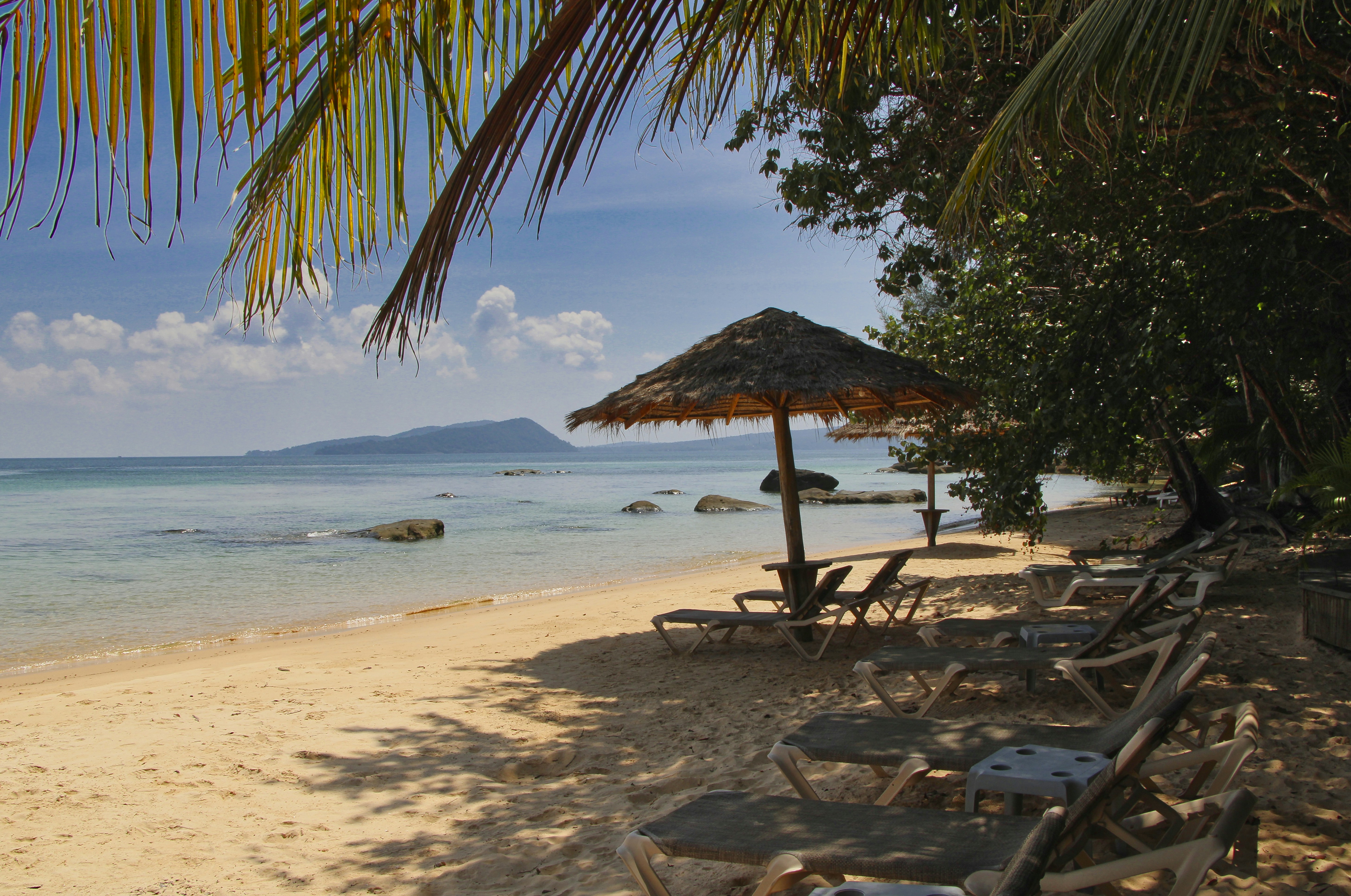 brown wooden beach lounge chairs on beach during daytime