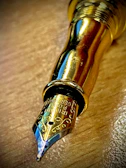Close-up of a vintage fountain pen nib glistening under soft light.