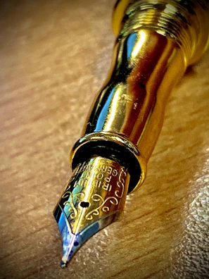 Close-up of a vintage fountain pen nib glistening under soft light.