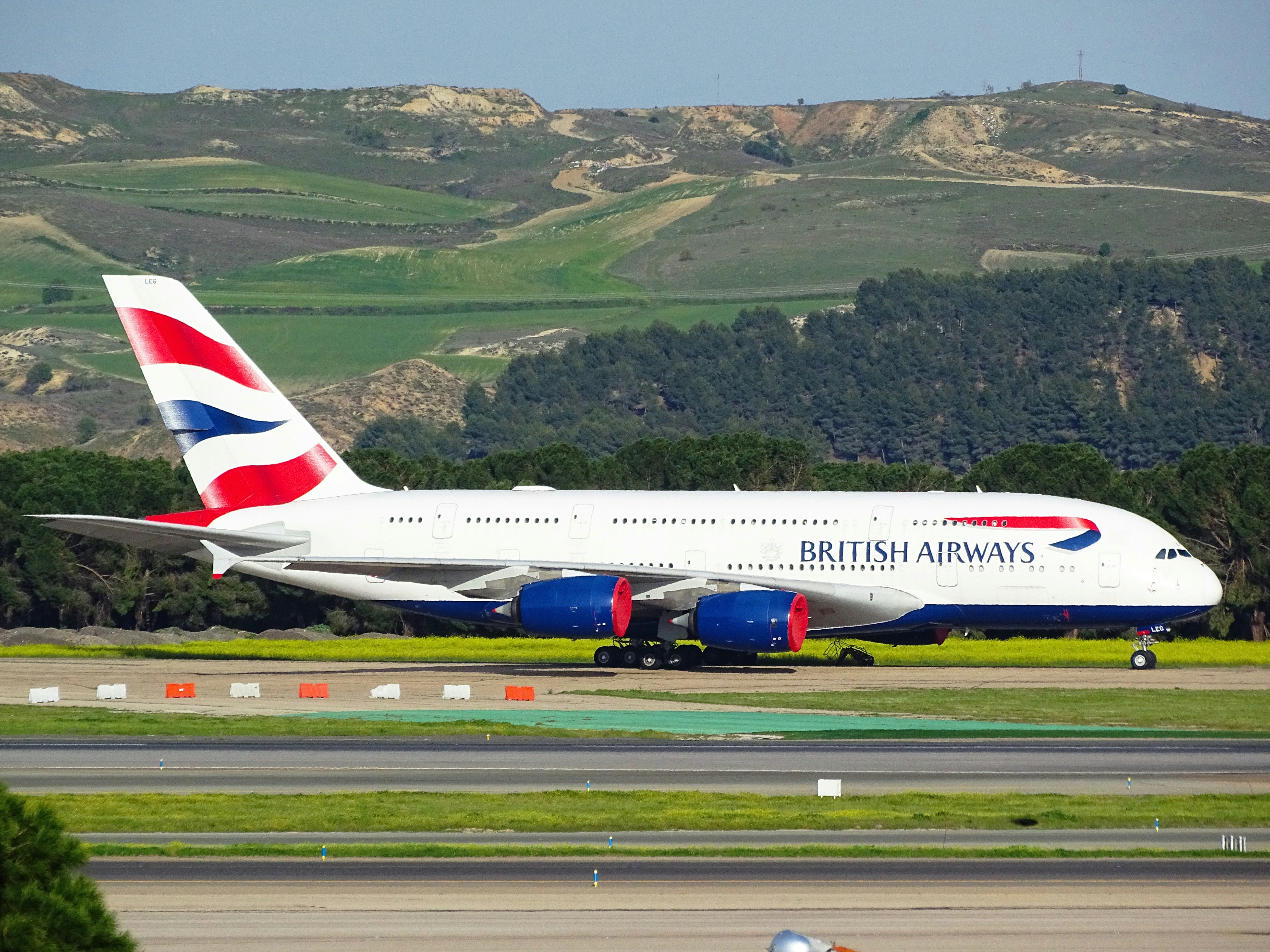 white and red air plane flying over green mountains during daytime, British Airways A380