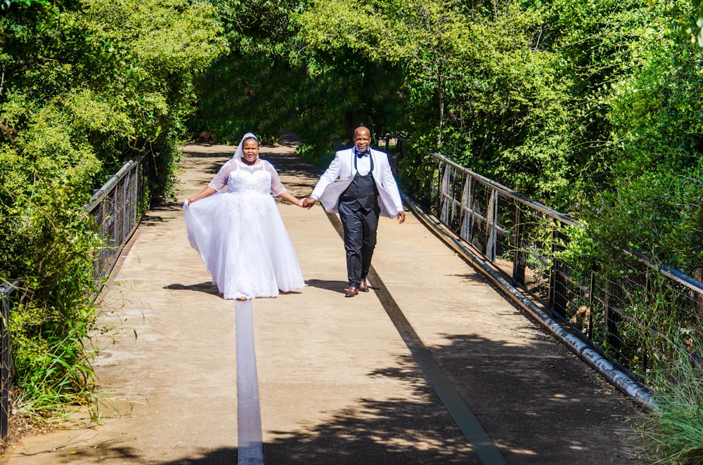 woman in white dress standing beside man in black suit jacket