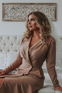woman in brown long sleeve dress sitting on white couch