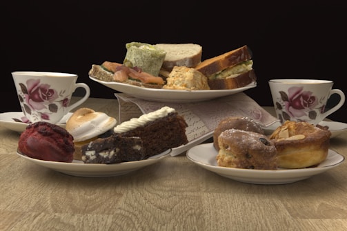 A plate with a variety of sandwiches and pastries on a rustic wooden table.
