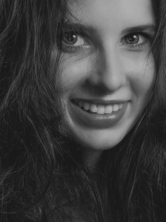 A close-up of a smiling woman with captivating eyes.