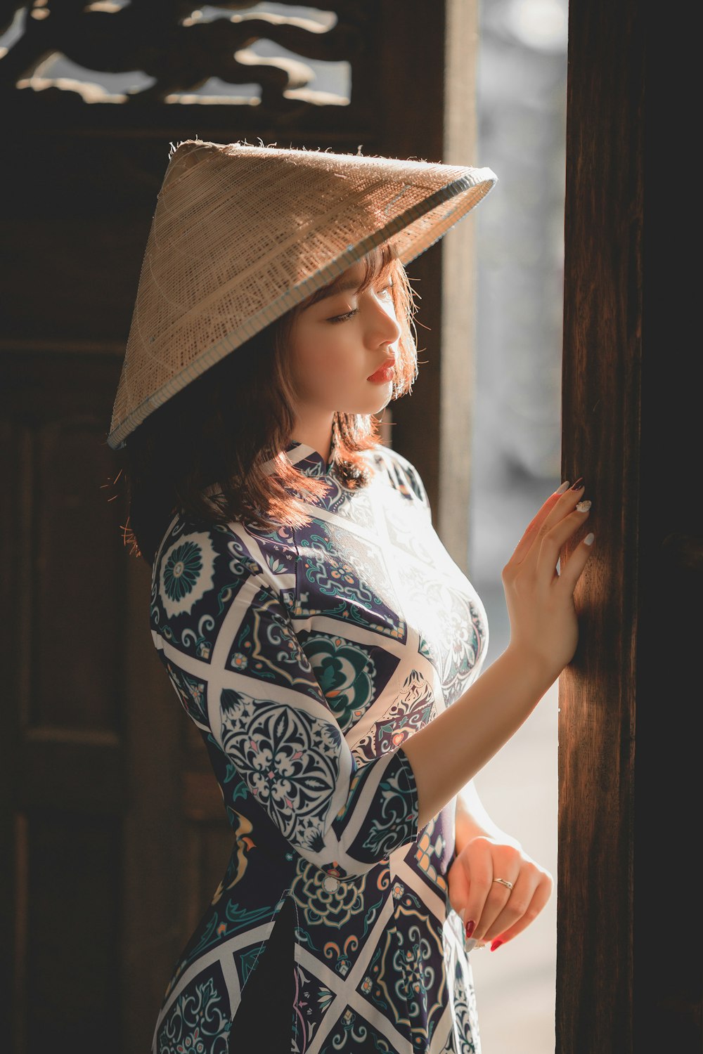 woman in white and black floral shirt wearing brown hat