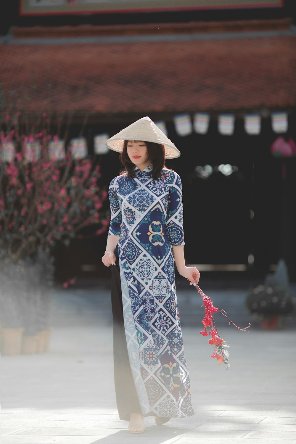 woman in blue and white floral dress wearing brown hat standing on street during daytime