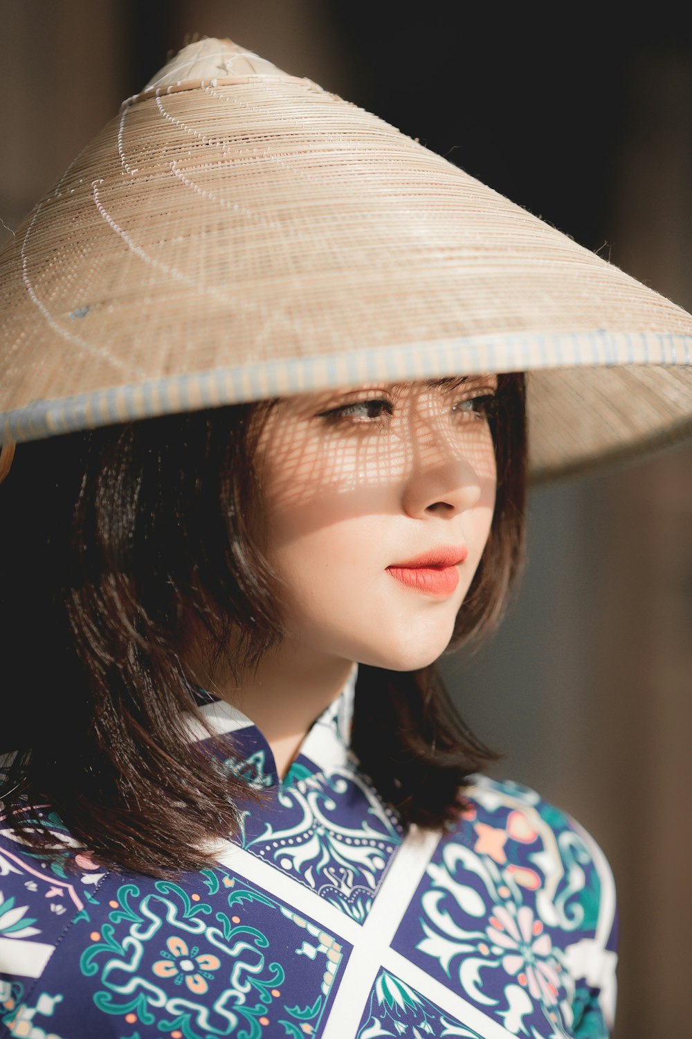 woman in blue white and red floral shirt wearing brown hat