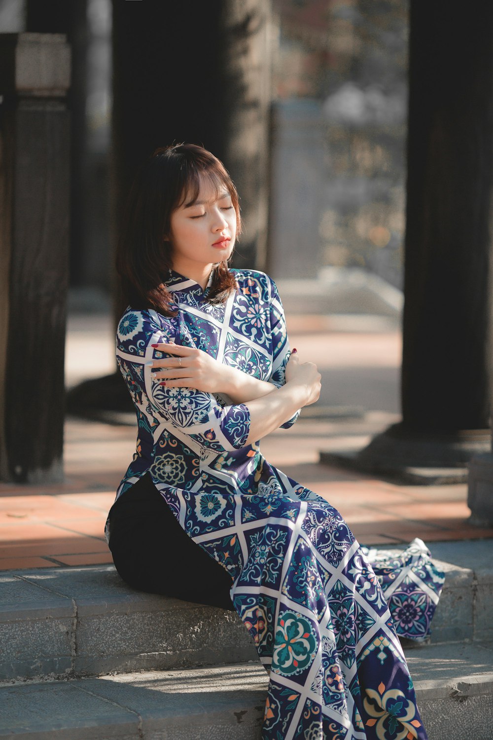 woman in blue and white floral dress sitting on the ground