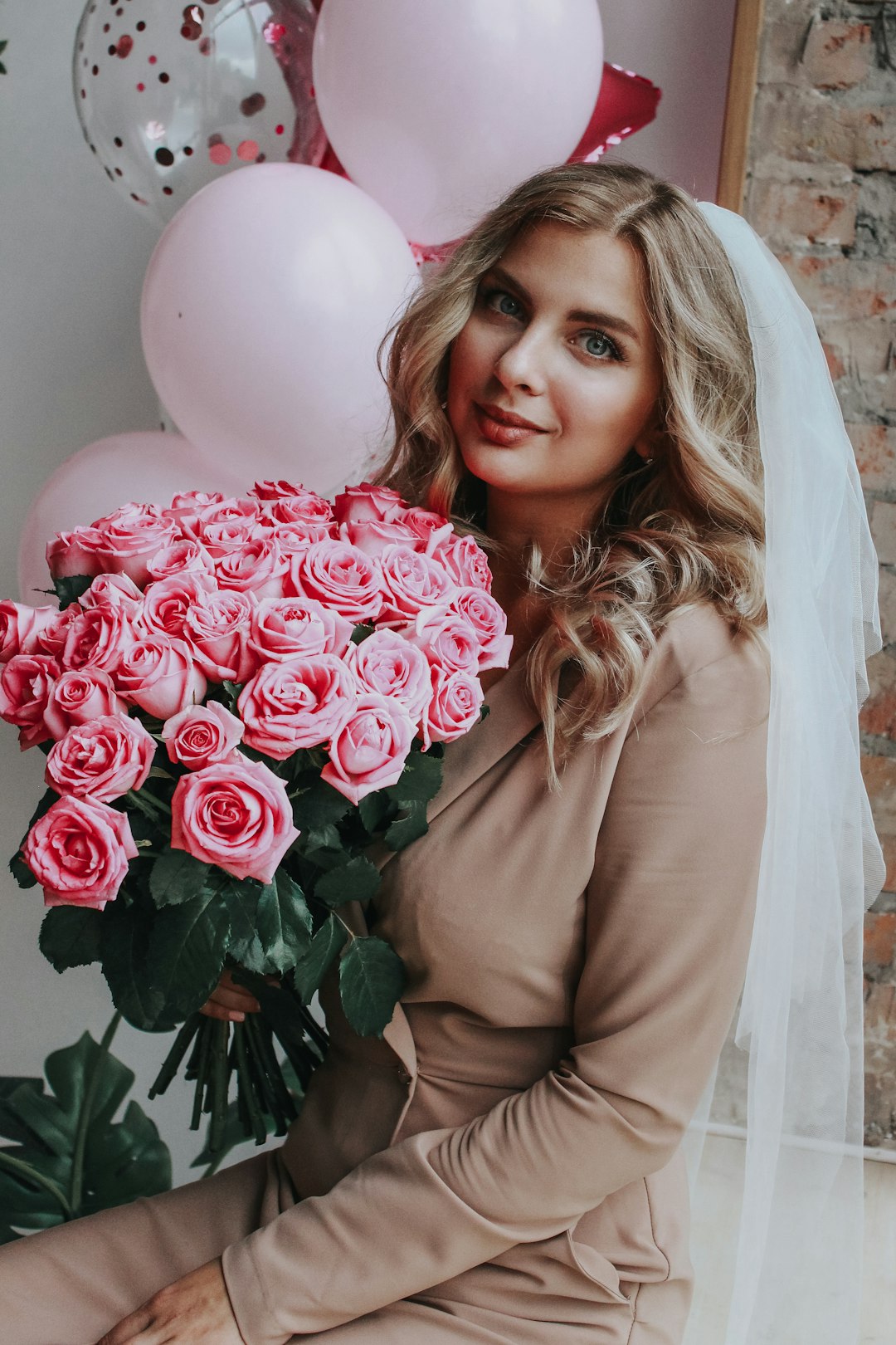 woman in brown long sleeve shirt holding bouquet of pink roses