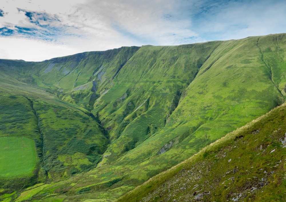 green mountain under white clouds during daytime