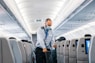 man in blue dress shirt standing in airplane