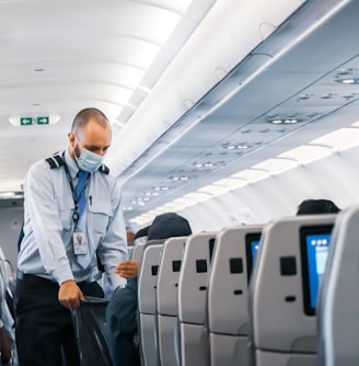 man in blue dress shirt standing in airplane