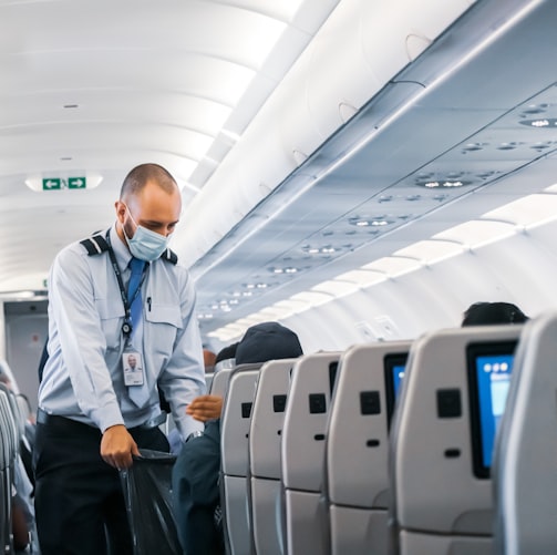 man in blue dress shirt standing in airplane