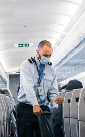 man in blue dress shirt standing in airplane