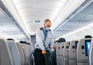 man in blue dress shirt standing in airplane