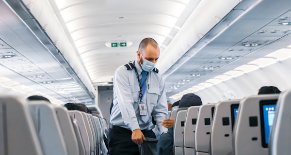 man in blue dress shirt standing in airplane