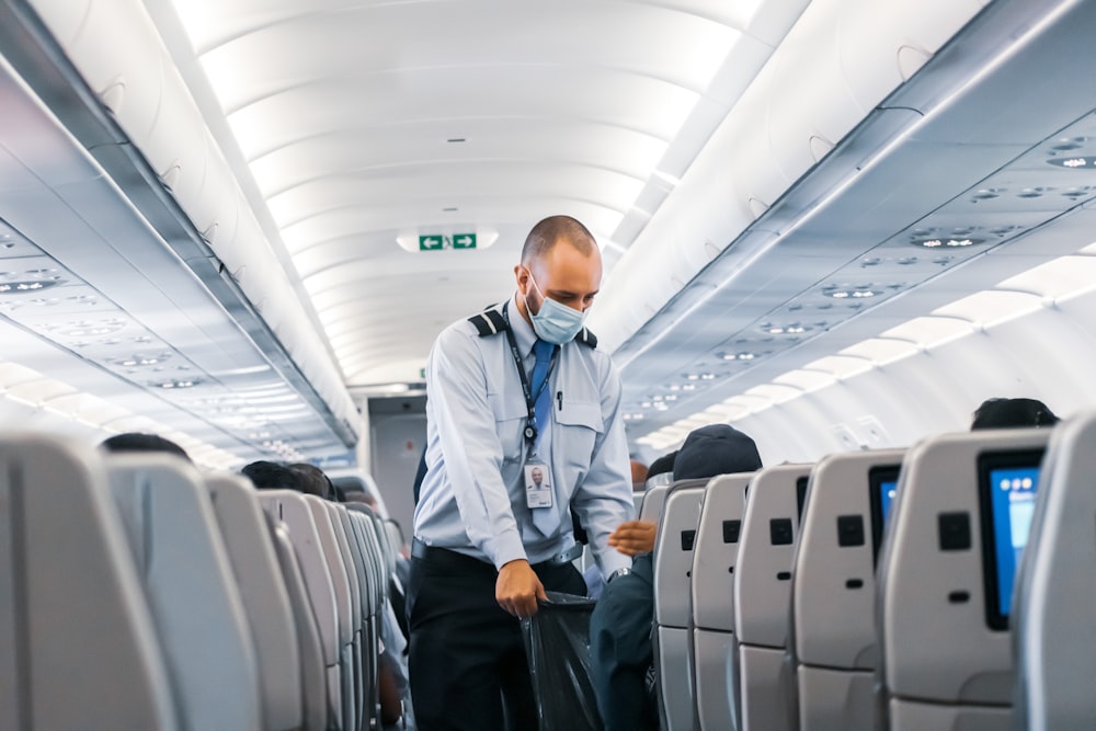Mann im blauen Hemd steht im Flugzeug