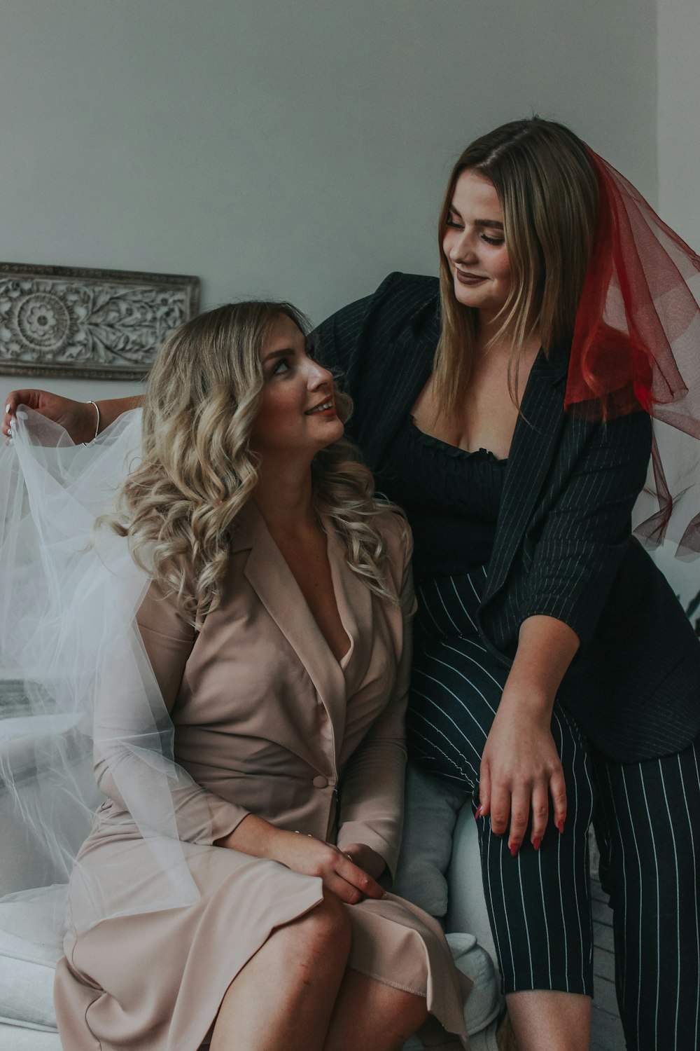 woman in black long sleeve shirt sitting beside woman in brown blazer