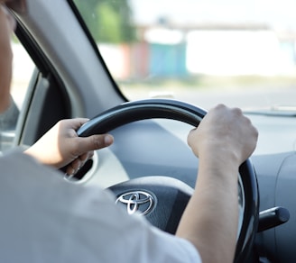 person in white long sleeve shirt driving car