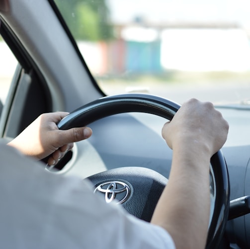 person in white long sleeve shirt driving car