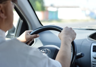 person in white long sleeve shirt driving car