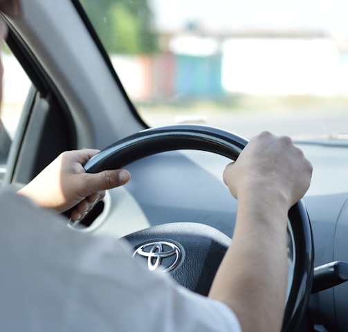 person in white long sleeve shirt driving car