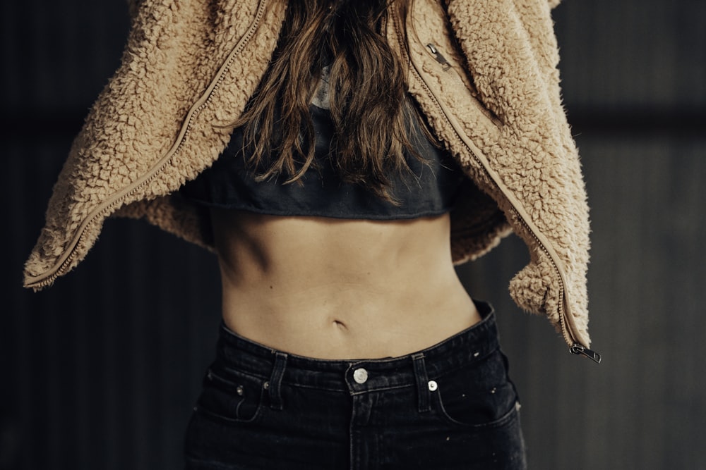 woman in black denim jeans and brown fleece coat