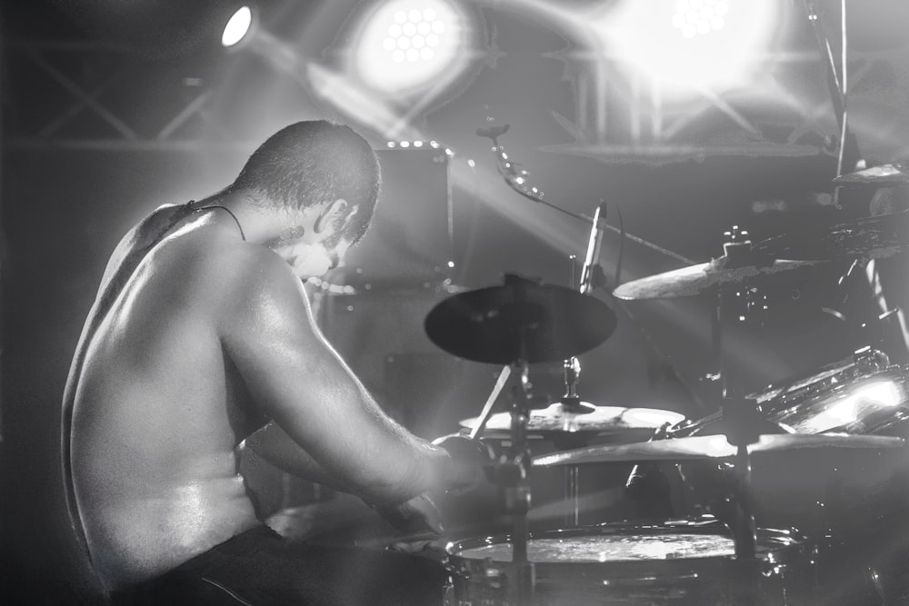 topless man playing drum set