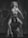 A black and white photo features a woman with curly hair and a bikini standing on the shoulders of a crouching man. The composition is dramatic and artistic, with a focus on their expressions and poses.