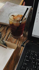 Person discussing ideas over a laptop with notes and coffee nearby.