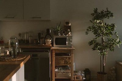 A compact microwave oven on a kitchen countertop with warm lighting.