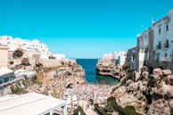 A coastal view of Chefchaouen’s blue-washed buildings under a bright turquoise sky.