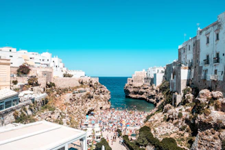 A coastal view of Chefchaouen’s blue-washed buildings under a bright turquoise sky.