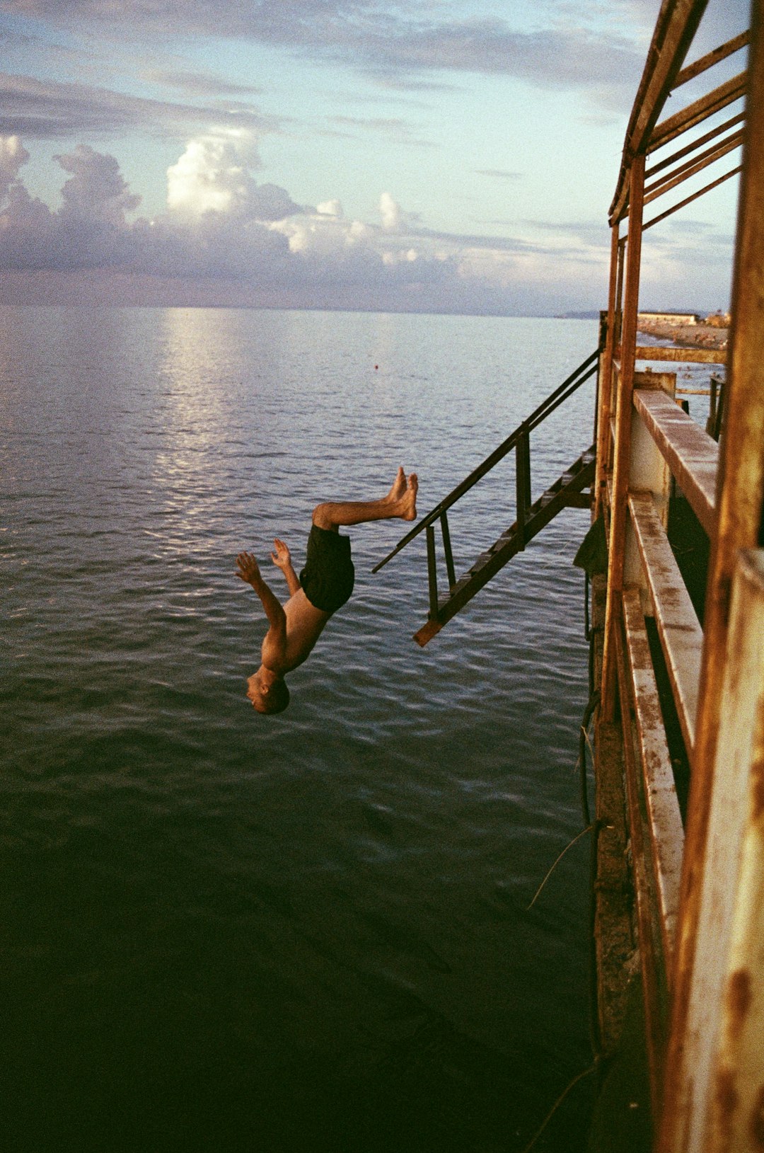 man in black shorts jumping on water during daytime