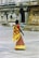 woman in yellow and red sari dress walking on white sand during daytime