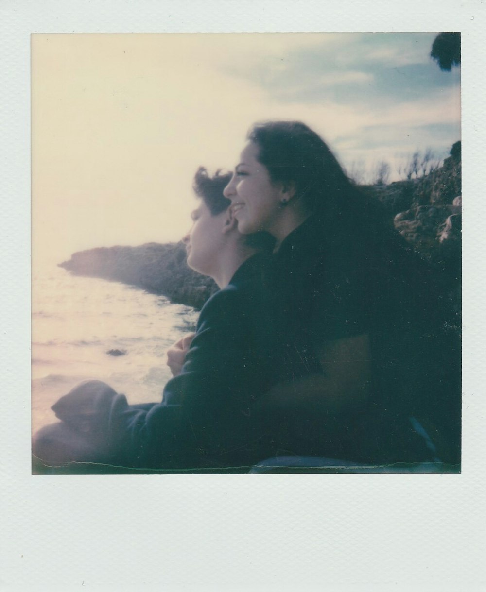 Mann und Frau küssen sich tagsüber am Strandufer