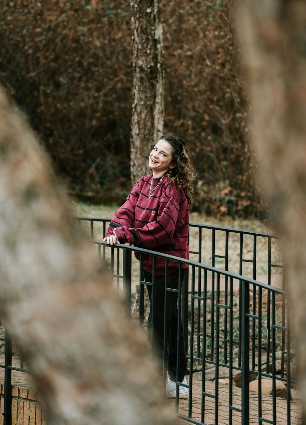 woman in red coat standing on bridge