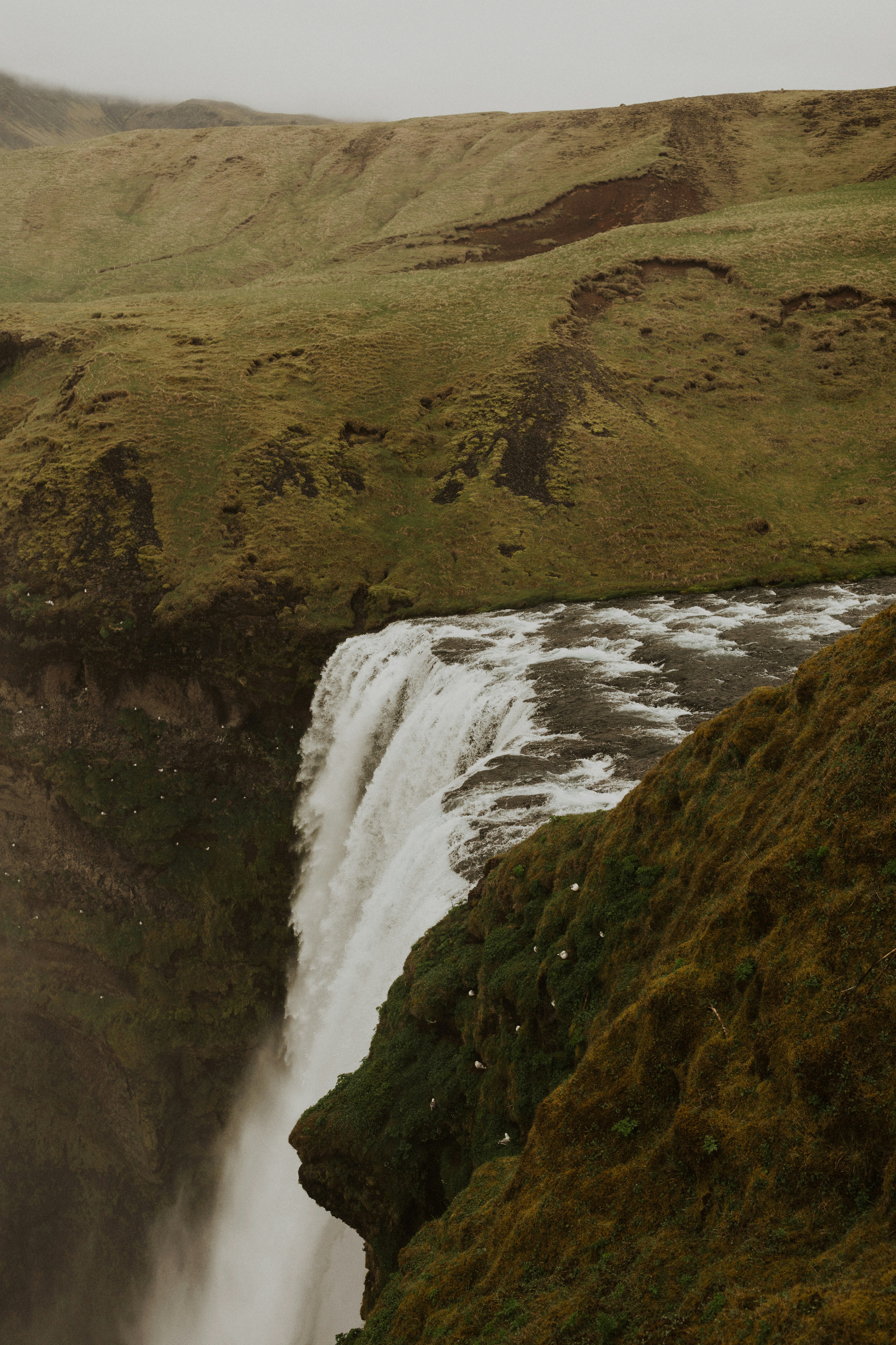 waterfalls on brown rocky mountain during daytime