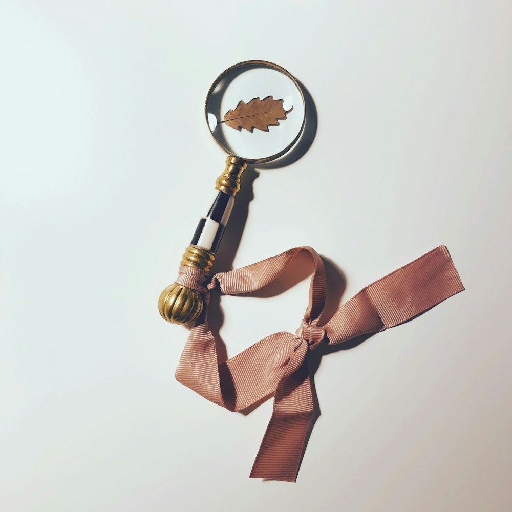 gold and brown ribbon on magnifying glass