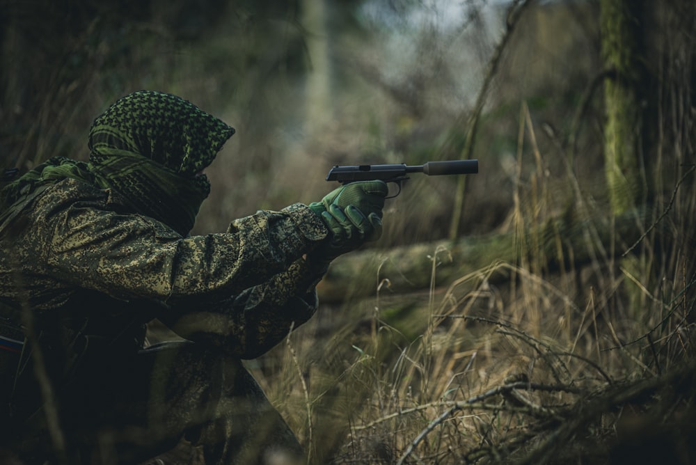 person in black and white polka dot coat holding black rifle