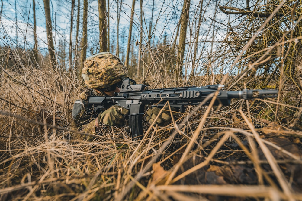 black and brown assault rifle on brown dried leaves