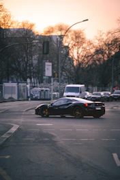 A sleek compact SUV navigating a bustling city intersection at sunset.