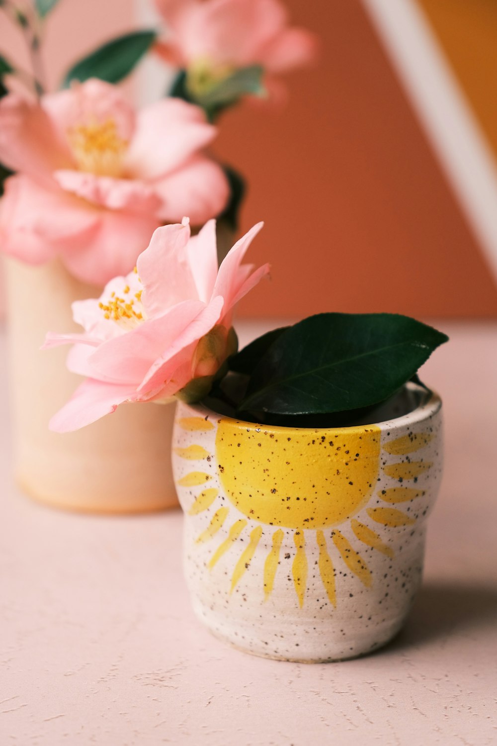 pink and white roses in white and yellow ceramic vase