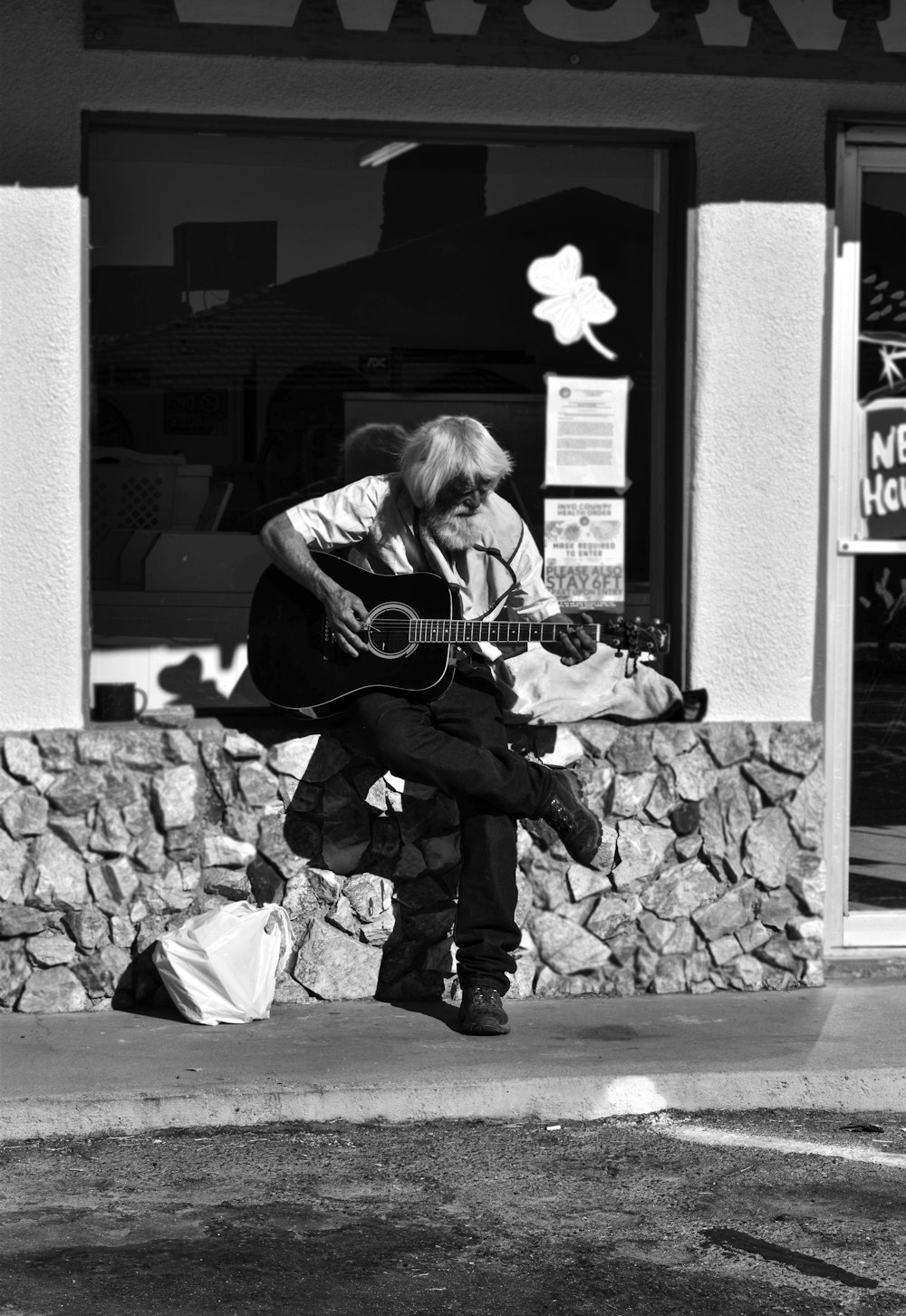 Frau spielt akustische Gitarre in Graustufenfotografie