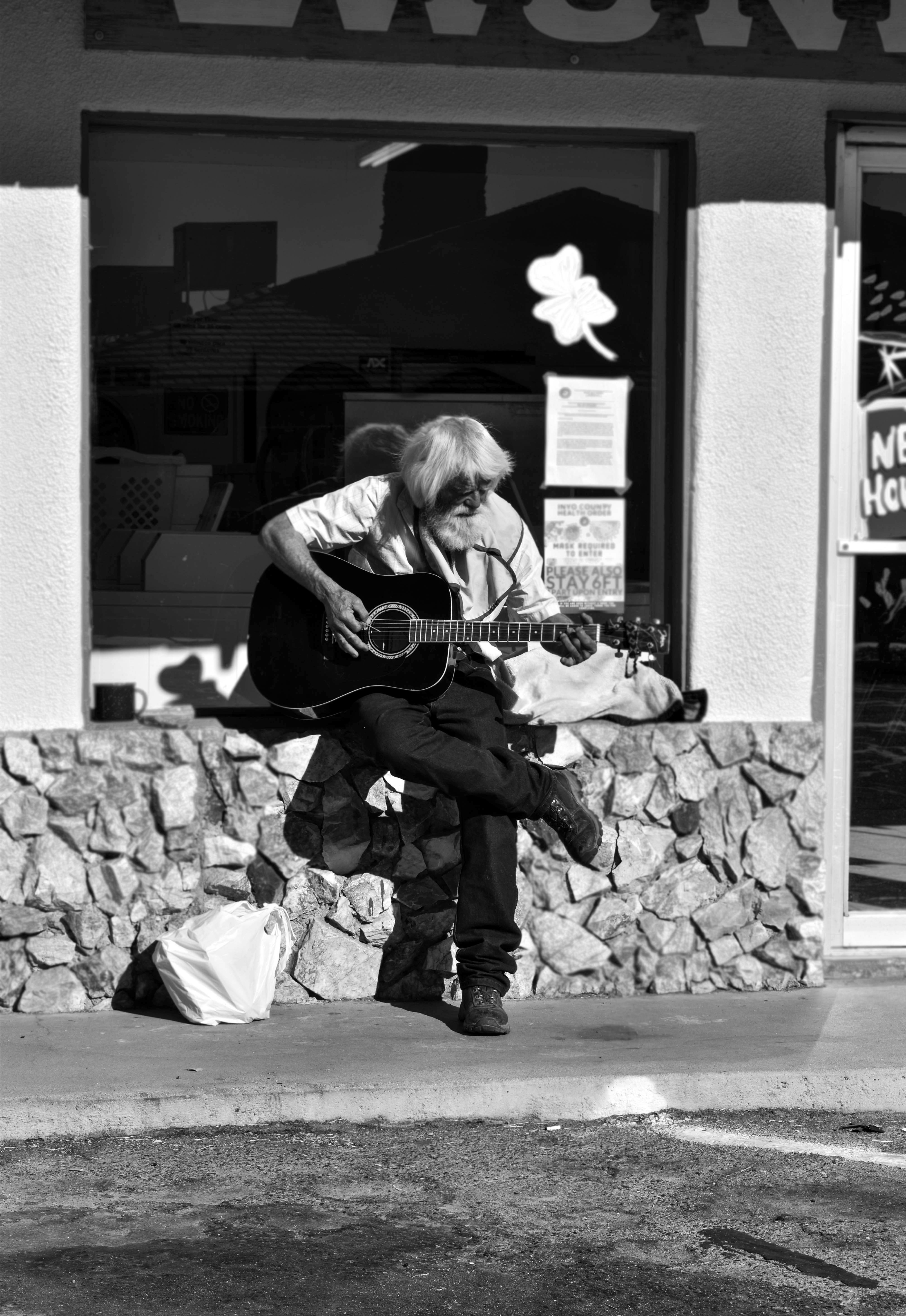 woman playing acoustic guitar in grayscale photography
